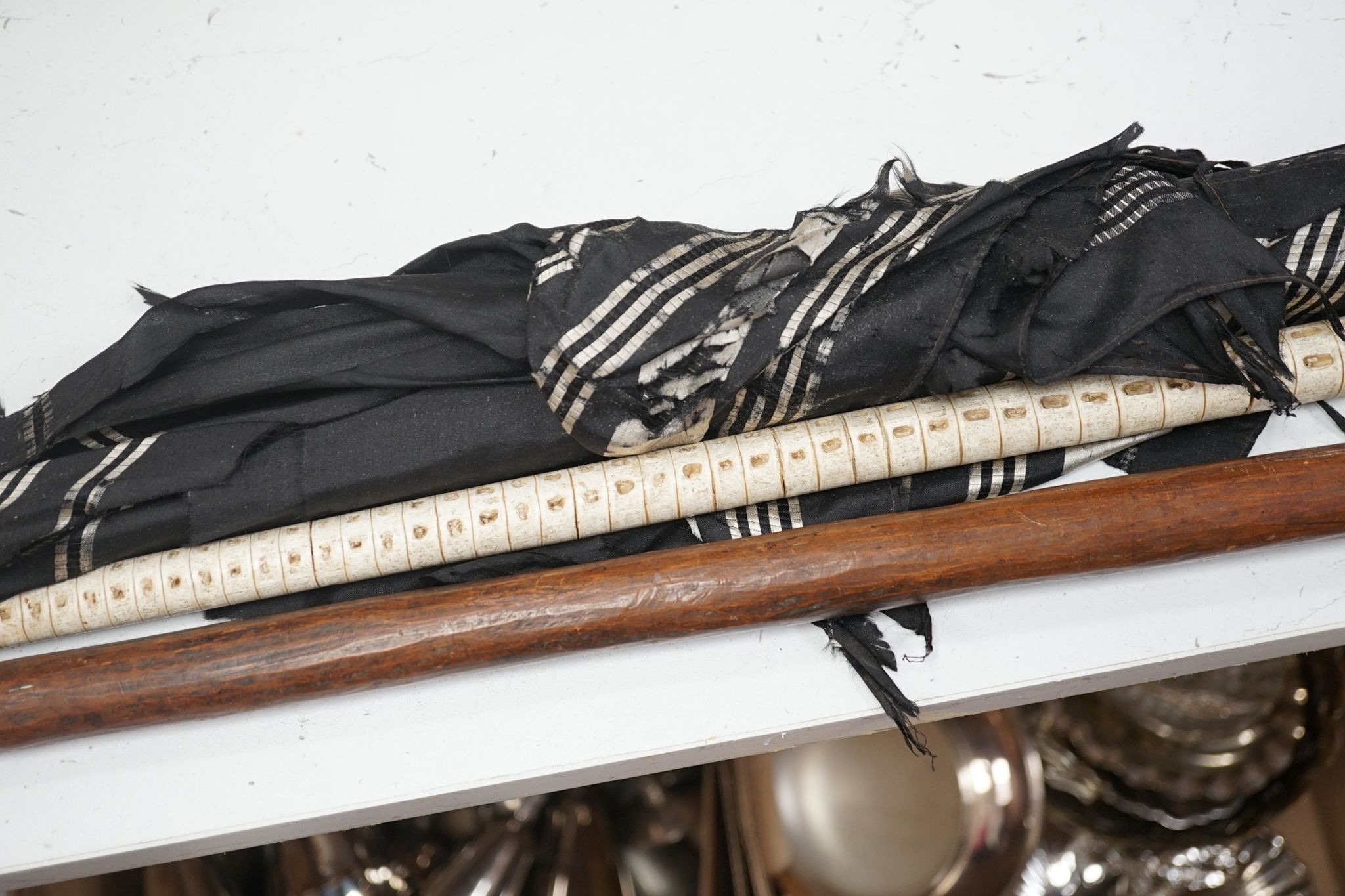 A carved wood figural walking cane, a vertebrae walking stick and a Victorian parasol. Longest 108cm